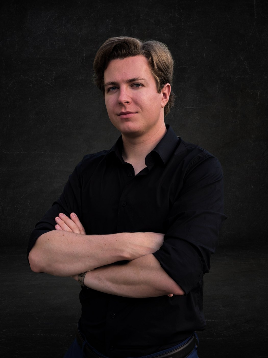 Studio portrait of Reed Tate with arms crossed